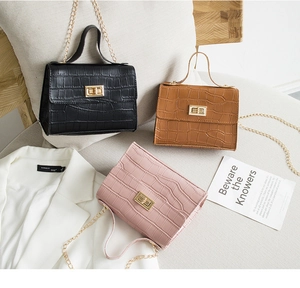 Détail de sacs à bandoulière gaufrés crocodile avec chaîne dorée en noir, marron et rose
