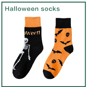 Detail of Halloween socks featuring skeleton bones, bats and pumpkin patterns on ribbed crew socks