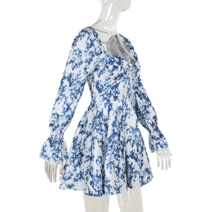 Détail des manches bouffantes et de l'encolure carrée sur une robe fleurie bleue ligne A