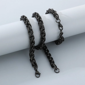 Dettaglio di una collana in acciaio inossidabile nero avvolta su un cilindro da esposizione