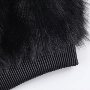 Détails de la texture en fausse fourrure noire et des poignets en maille côtelée