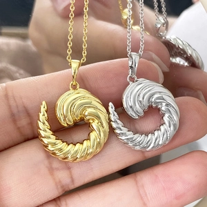 Macro shot of gold and silver twisted spiral pendant necklace with detailed metallic texture