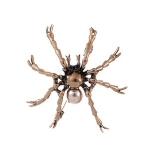 Détail de la broche araignée vintage bronze avec perle nacrée et pattes texturées