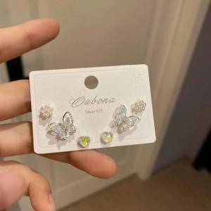 Macro shot of 925 silver stud earrings set featuring floral, butterfly and heart designs