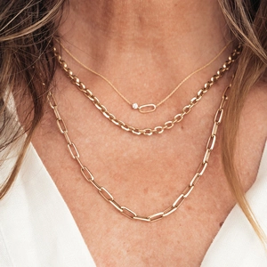 Detailed layered look of 18K gold paperclip, cable, and crystal pendant necklace set