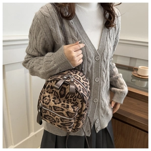Detail eines Mini-Rucksacks mit Leopardenmuster, Doppel-Reißverschluss und Lederlaschen
