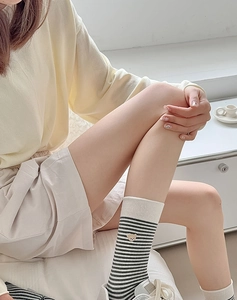 Detail von Baumwollstreifensocken mit Bärenstickerei und beigem geripptem Bündchen am Rand