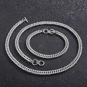 Close-up of silver stainless steel Cuban chain set with OT toggle clasp on dark background