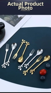 Macro shot of creative leaf handle stainless steel dessert forks and spoons on a dark mat