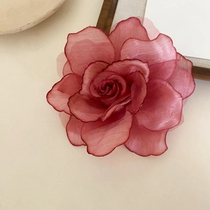 Detailed macro shot of a gradient pink fabric rose hair clip with delicate organza petals