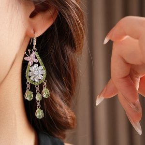 Dettaglio orecchino floreale argento con zirconi rosa e nappine a goccia verdi