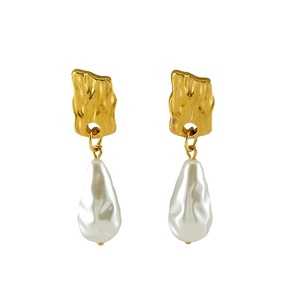 Détail des boucles d'oreilles dorées à texture martelée et perles baroques