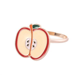Detail of apple-shaped enamel napkin ring with red outer shell and golden metallic rim