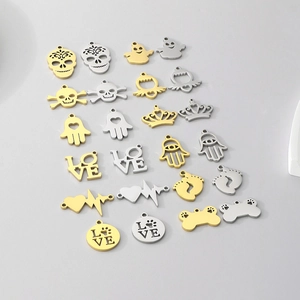 Flat lay detail of assorted stainless steel DIY pendants with skull, crown and love designs