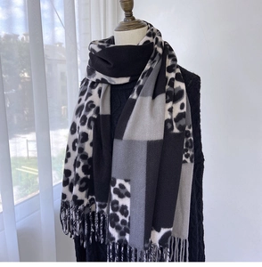 Detail of winter scarf featuring leopard print patchwork, tassels and soft cashmere texture