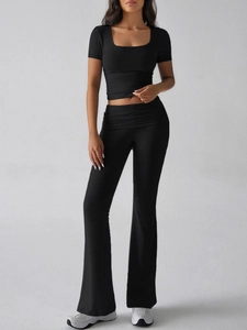 Full body view of black Y2K style square neck crop top and high waist flared yoga pants set