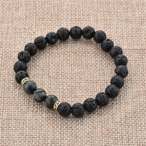Vue macro des perles de lave noire et pierres naturelles vertes sur tissu de chanvre