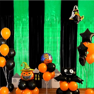 Close-up of black and green foil fringe curtains with Halloween party balloon decor