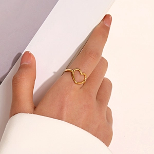 Minimalist hollow heart-shaped open ring in gold finish worn on finger for jewelry display