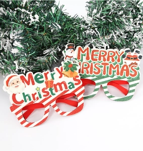 Detail of glitter Christmas party glasses with Santa and Snowman motifs on snowy pine branches