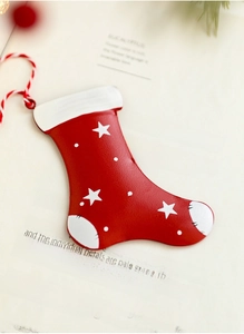 Makroaufnahme einer roten Weihnachtsstrumpf-Deko aus Eisen mit Sternen auf festlichem Papier