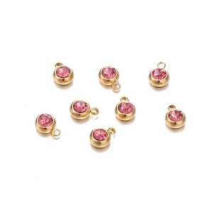 Vue macro de breloques en zircon rose 6mm avec montures en acier inoxydable doré