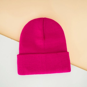 Detailed macro view of vibrant rose red ribbed knit texture on a cozy cuffed beanie