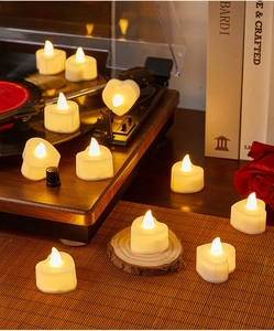 Close-up of heart-shaped LED candles with warm yellow light for romantic decoration