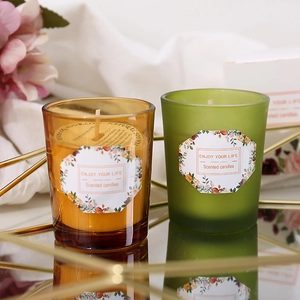 Aromatic soy wax candles in amber and green glass jars on a mirrored tray decoration