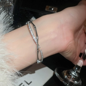 Detailed view of silver crisscross bangle with micro-pave zircons and bamboo texture