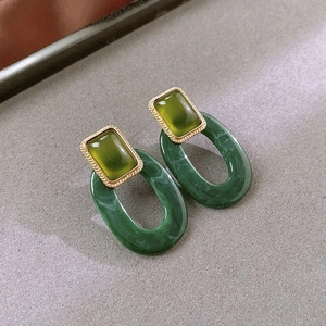 Macro shot of vintage green marble resin earrings with textured gold-tone metal frames