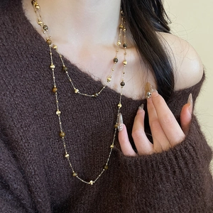Close-up of double-layer 18k gold plated necklace with tiger eye beads on a model