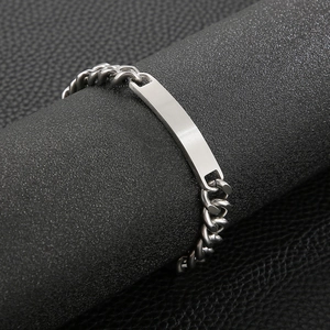 Close-up of silver stainless steel Cuban link bracelet with curved ID plate on display