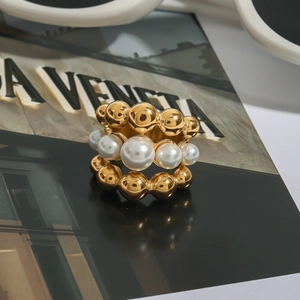 Detailed view of wide gold beaded ring featuring three layers with inset white pearls