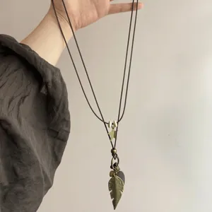 Bohemian long necklace with bronze leaf and heart charms on a black leather cord