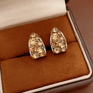 Gros plan détaillé de boucles d'oreilles en U avec cristaux de couleur champagne