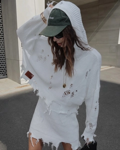 Détails d'un ensemble blanc en maille avec pull à capuche et jupe style déchiré
