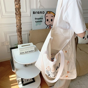 Detail of white canvas tote bag with artistic graffiti print and interior pocket