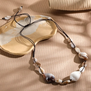Detailed close-up of Bohemian handmade shell necklace with natural textures and brown cord