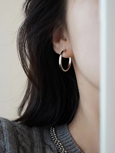 Close-up of minimalist S925 sterling silver hoop earring worn by a female model