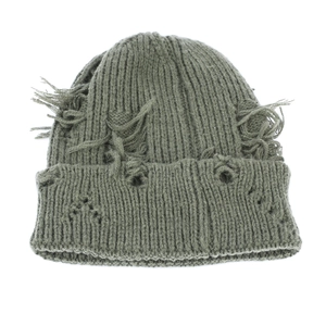 Detail shot of distressed grey-green knit beanie with ripped holes and frayed edges
