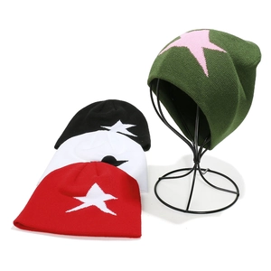 Bonnets en maille avec étoile en vert, noir, blanc et rouge sur un support d'exposition