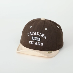 Close-up of brown and beige soft brim baby cap with Catalina 1983 embroidery