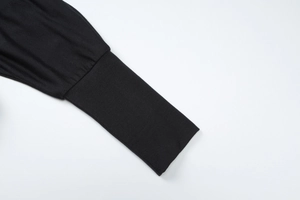 Gros plan du poignet en maille noire côtelée d'un haut à manches longues pour femmes