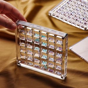 Clear acrylic magnetic storage box for butterfly nail charms on golden silk background