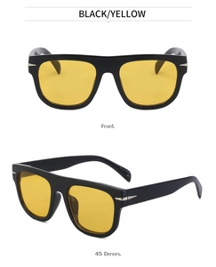 Close-up of black retro oversized sunglasses with yellow lenses and arrow metal detail