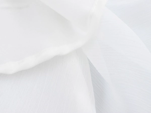 Gros plan sur la texture du tissu blanc et les coutures de la robe dos nu élégante