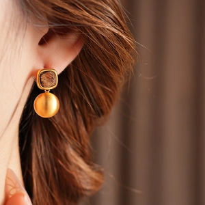 Close-up of model wearing French vintage brown leopard print round dangle earring