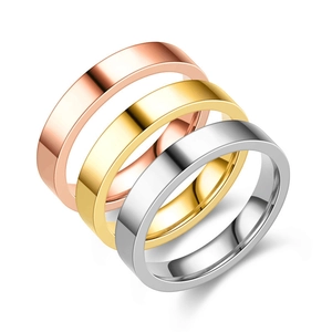 Detailed view of three minimalist plain band rings in rose gold, gold, and silver finishes