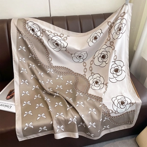 Détail d'un foulard en soie avec imprimés floraux de camélia et motifs de nœuds